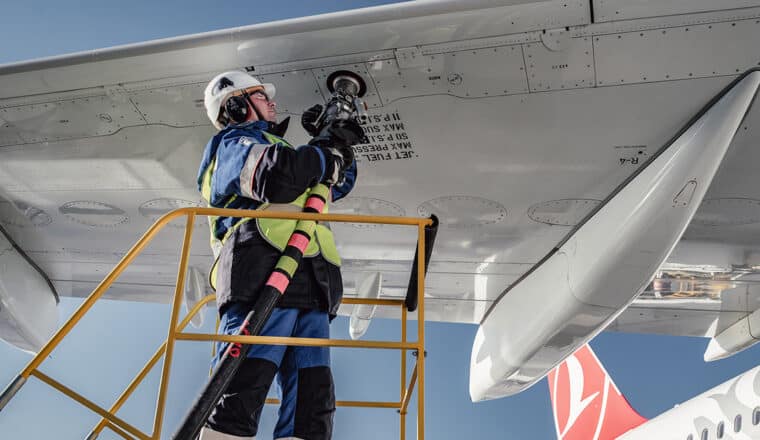 Специалист «Газпром нефти» заправляет самолет в крыло