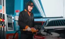 Водитель заправляет автомобиль на станции на сети АЗС «Газпромнефть»