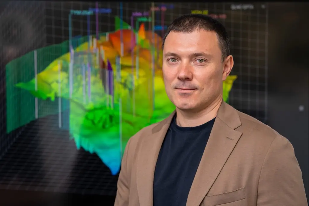 Данил Солодов рядом с 3D-моделью геологических пород