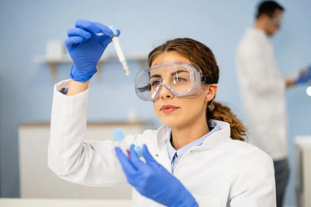 Специалист химической лаборатории рассматривает образец сконденсированного газа