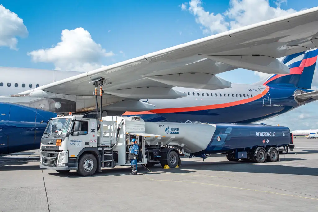 Водитель топливозаправщика «Газпром нефти» заливает авиатопливо в крыло самолета