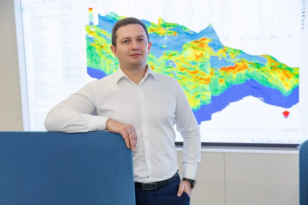 Владислав  Деревянко на фоне 3D-модели геологических пород