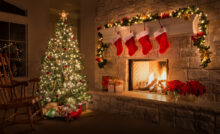 Украшенная гирляндами елка в каминном зале