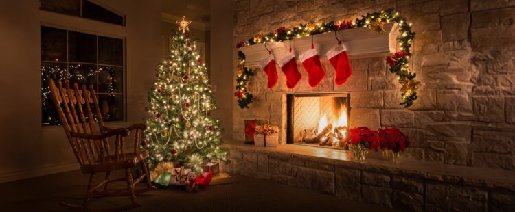 Украшенная гирляндами елка в каминном зале