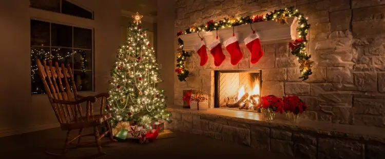 Украшенная гирляндами елка в каминном зале