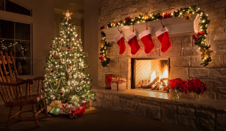 Украшенная гирляндами елка в каминном зале