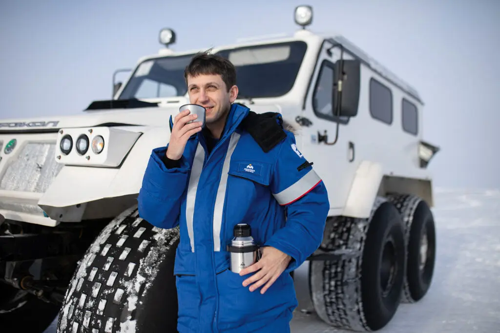 Нефтяник пьет чай из термоса на вахте