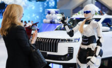 Человекоподобный робот возле нового российского автомобиля на ПМЭФ-2026
